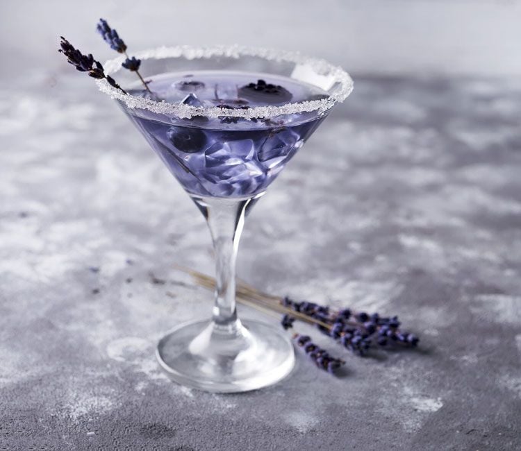 Cóctel de martini blanco con violeta y arándanos