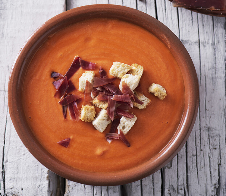 Cazuela de barro con salmorejo y trozos de jamón y de pan