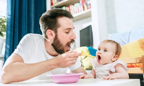Padre dando de comer a un bebé