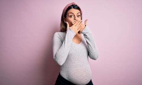 Mujer embarazada con las manos en la boca
