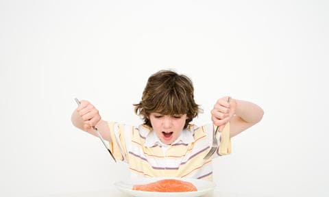 Niño comiendo salmón, rico en omega 3