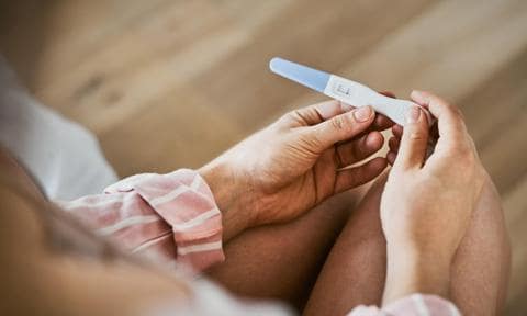Fertilidad o proceso de reproducción: genera ansiedad. Mujer mirando un test de embarazo.