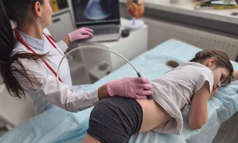 Médico haciendo una ecografía renal a niña