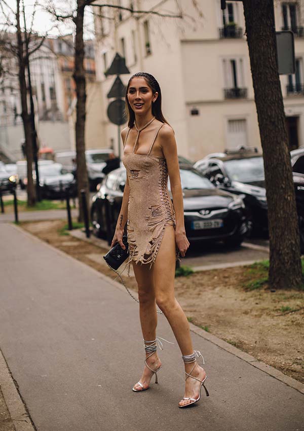 Una asistente a los desfiles de París lleva sandalias trepadoras con minivestido