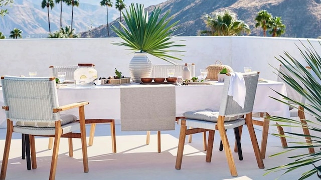 Mesa de exterior decorada en tonos blancos, grises y azules con un valle de montañas en el fondo.