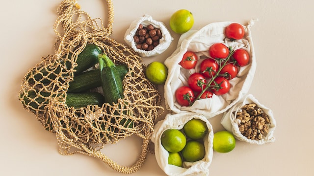 Bolsas de la compra reutilizables con materias primas saludables: tomate, nueces, limas y calabacines