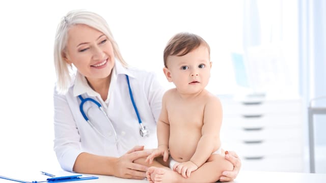 Bebé de meses sentado en la consulta de la pediatra