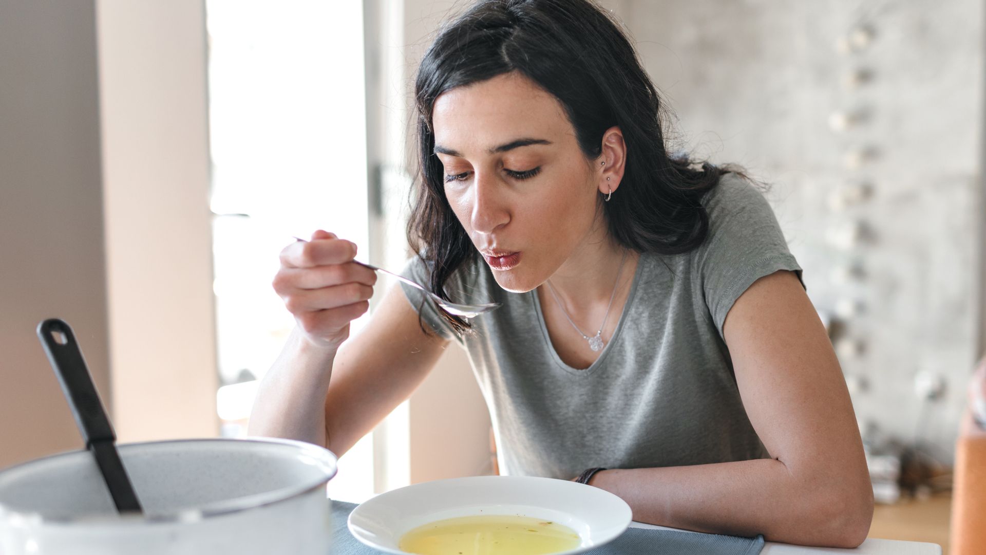 Mujer tomando sopa 