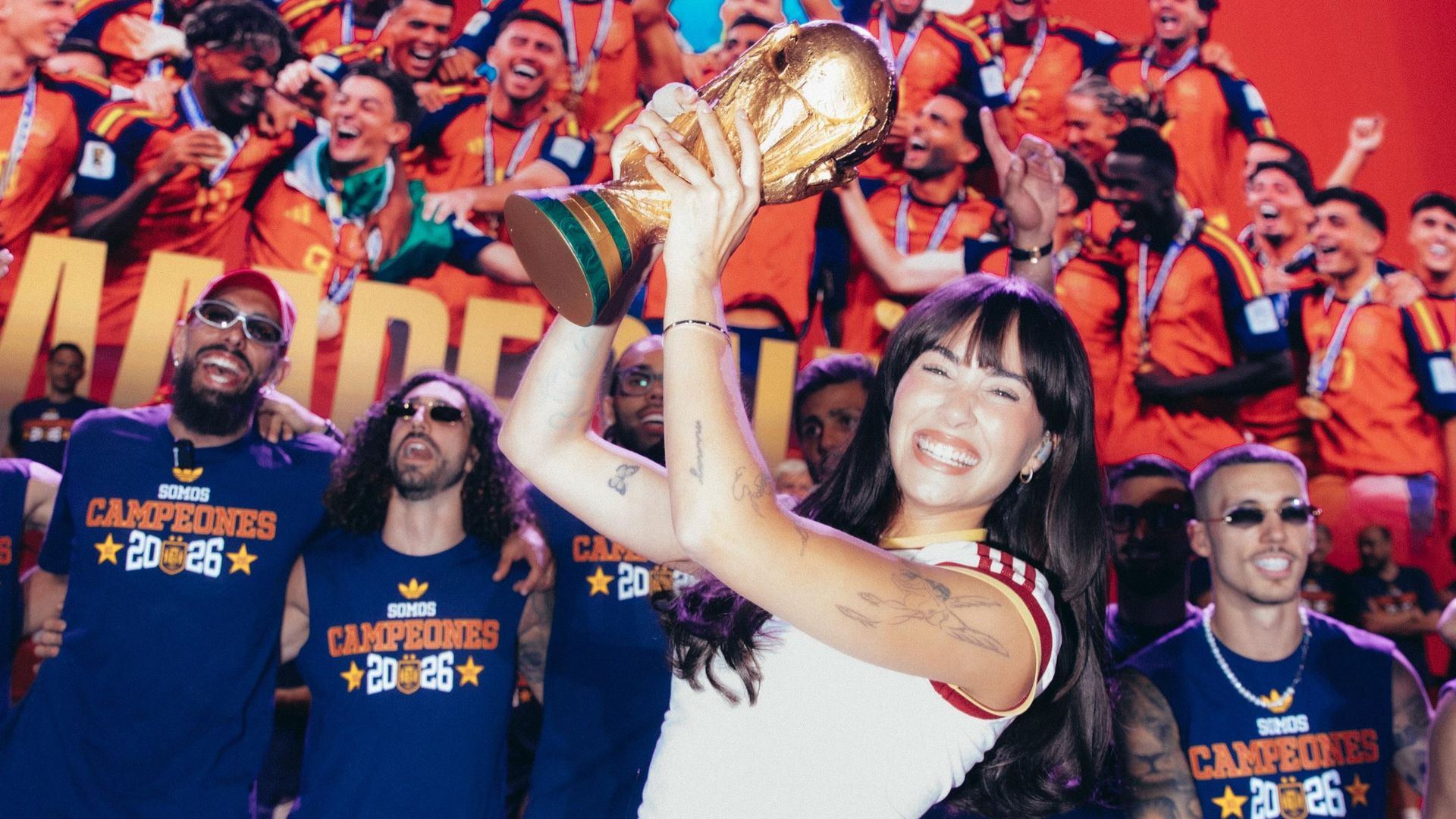Aitana sostiene el trofeo rodeada de los futbolistas de la Selección Española