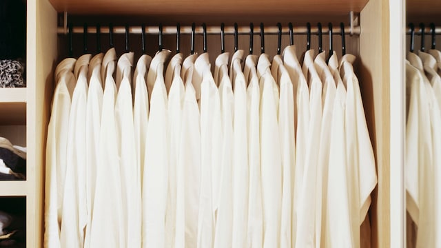 Camisas blancas colgadas en perchas mágicas en el armario