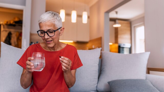 Mujer senior tomándose un medicamento