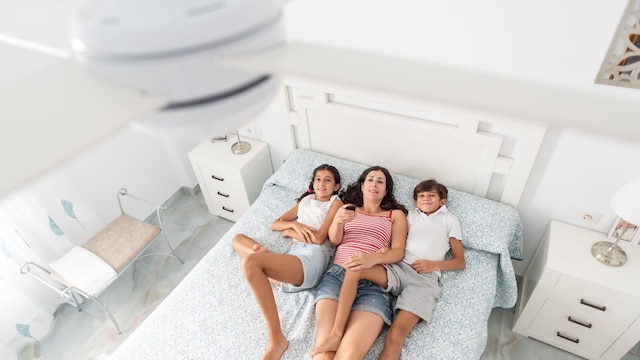 Una familia durmiendo debajo de un ventilador de techo