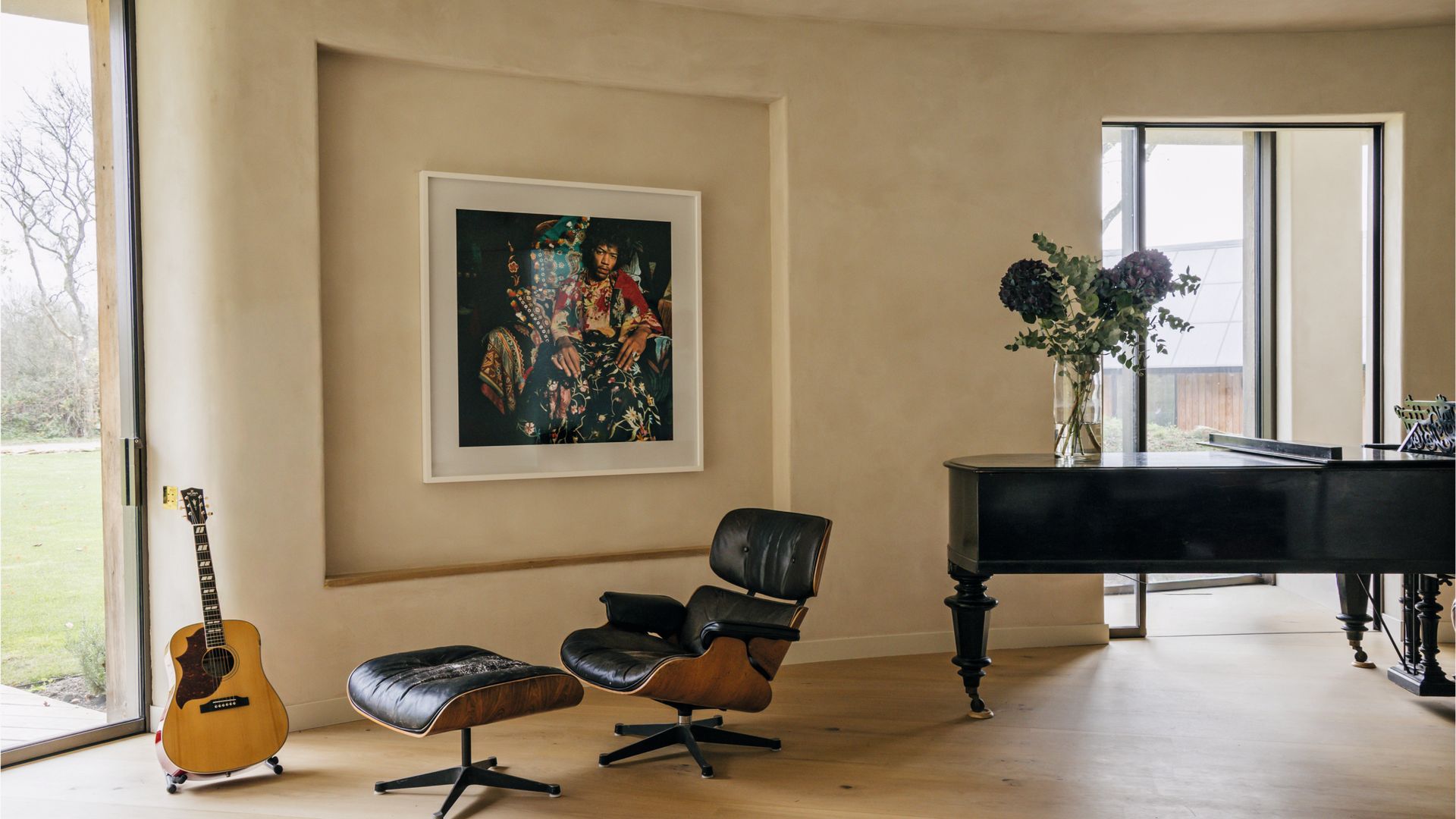 Otra vista del salón con piano, silla y cuadro enorme en la pared