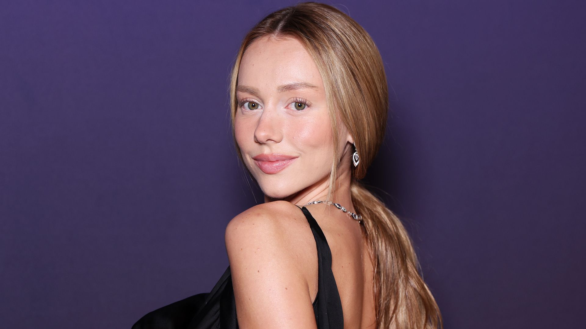 Ester Expósito con vestido negro, coleta suelta y joyas de Messika