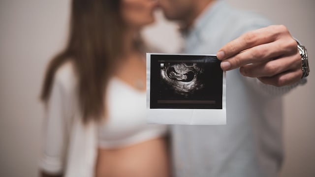 Pareja enseñando una ecografía de su bebé