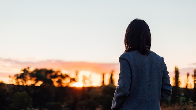 mujer mira al ocaso