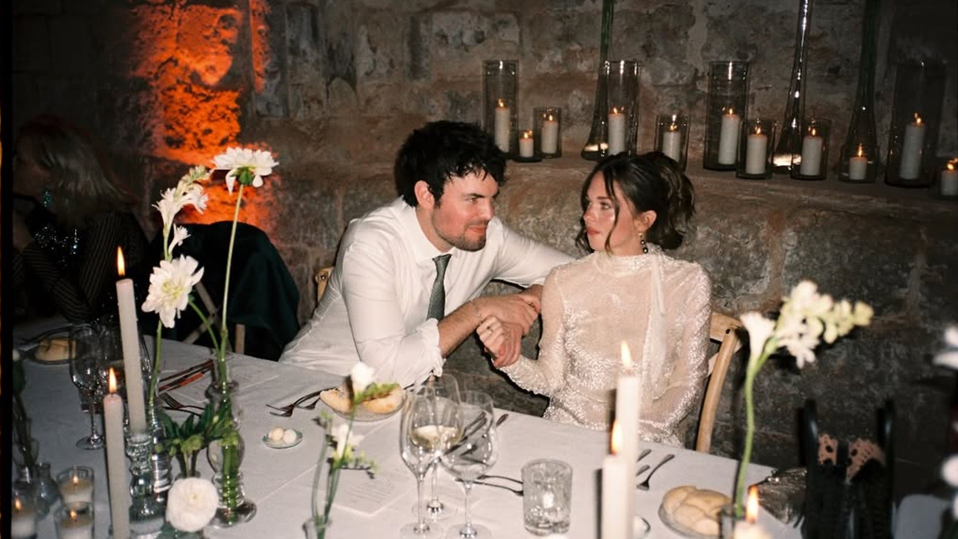 Los recién casados protagonizaron momentos llenos de complicidad. Una de las imágenes los muestra cogidos de la mano durante la cena, rodeados de flores y velas
