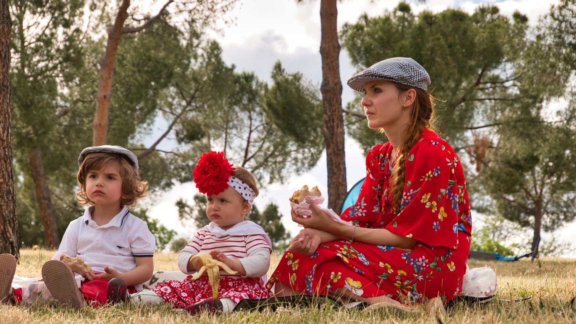 Madre con hijos comiendo en la pradera de San Isidro