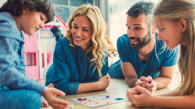 Familia jugando a un juego de mesa en el suelo
