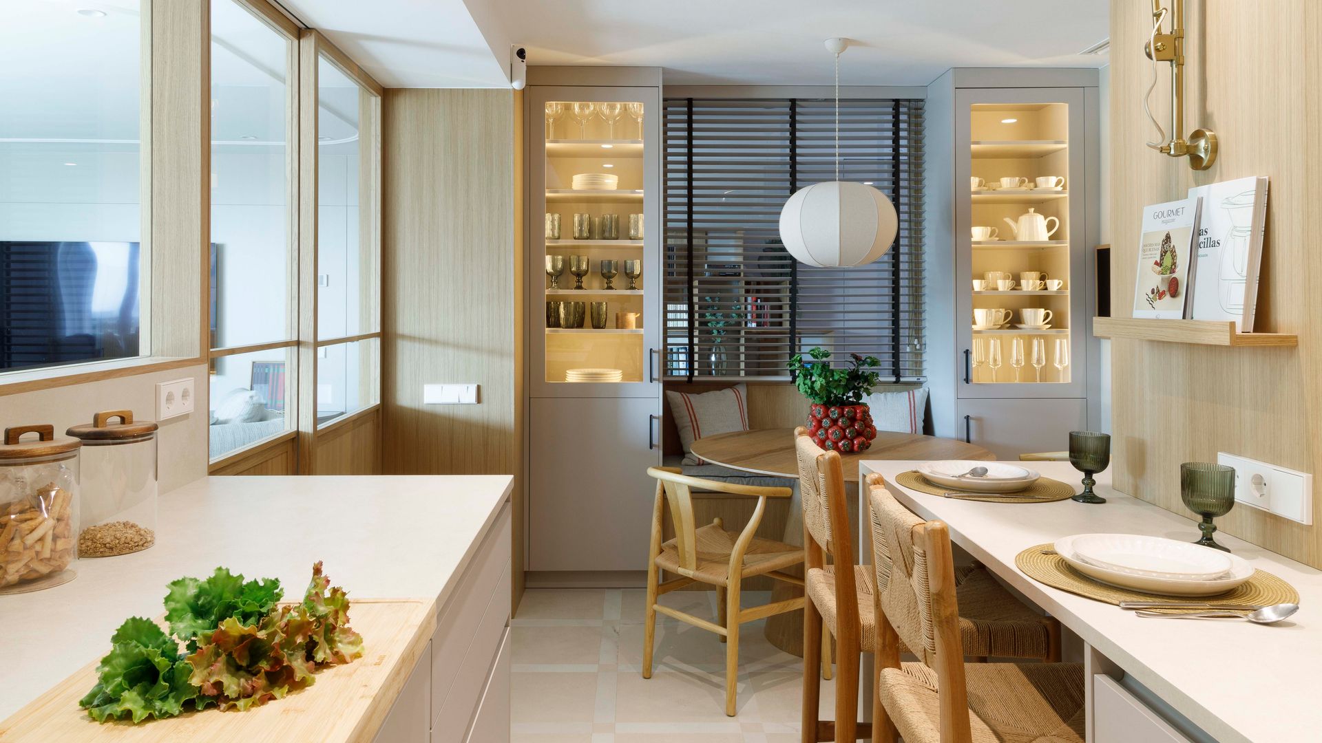 Cocina con comedor y zona de barra, vitrinas grises de suelo a techo con luz interior