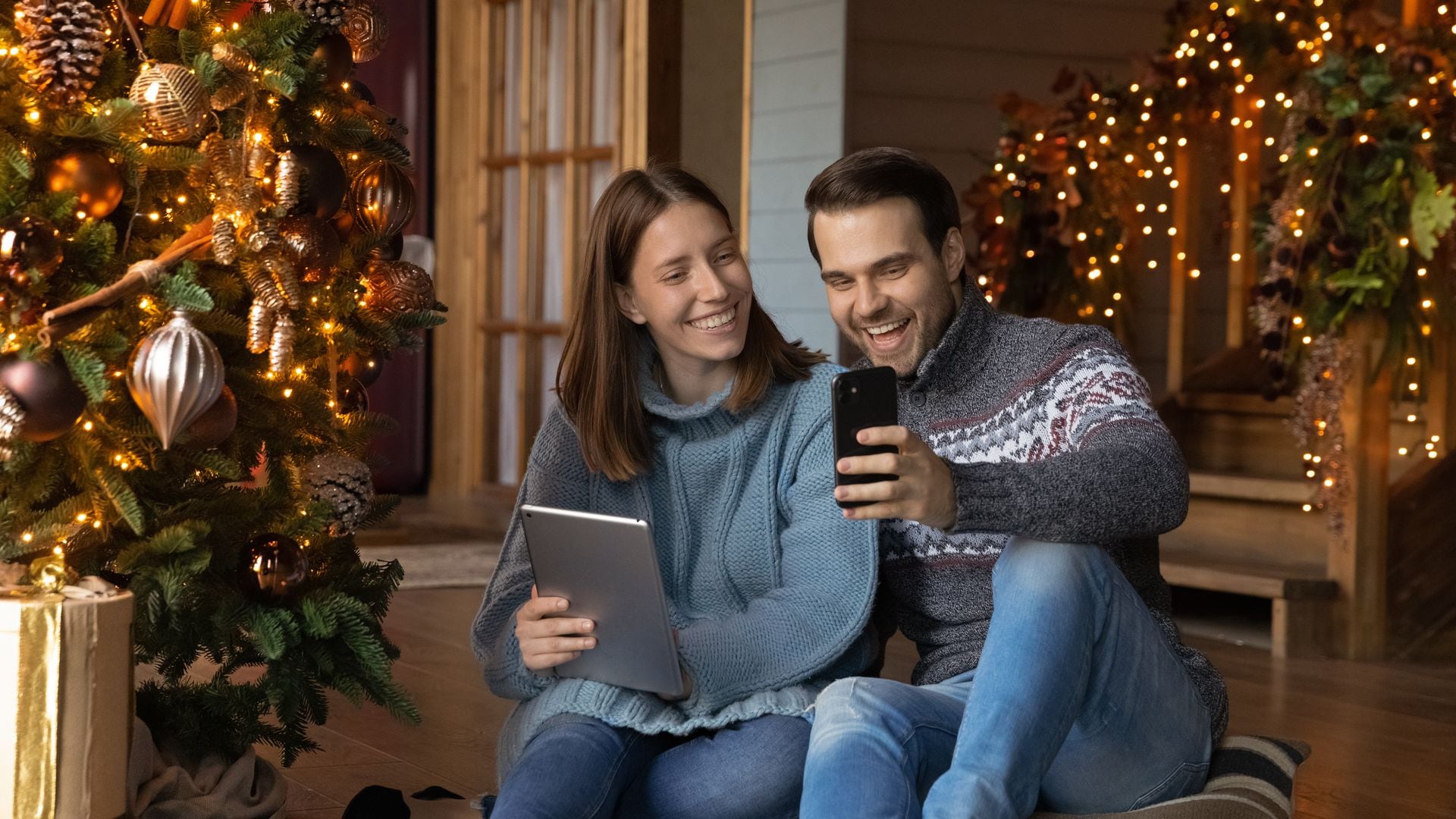 Pareja mirando su telefono movil en Navidad