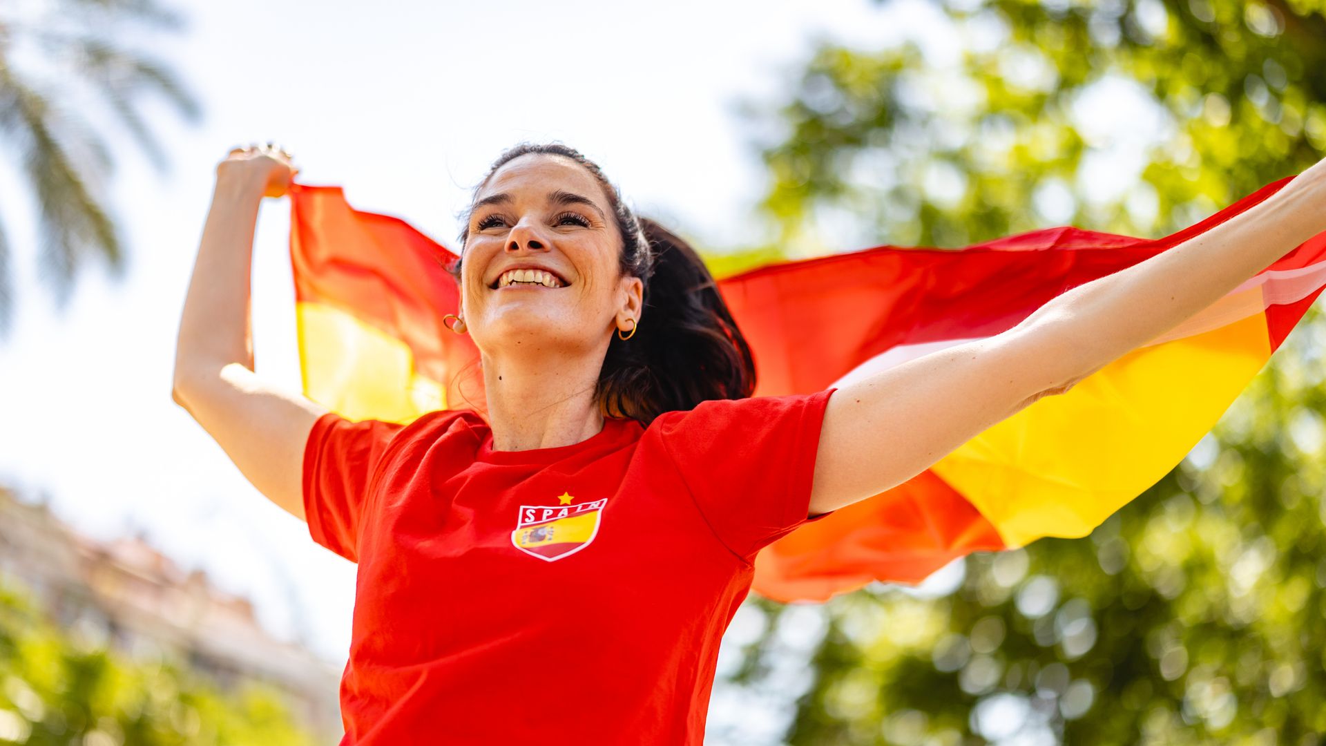Mujer llevando la bandera de España celebrando la victoria