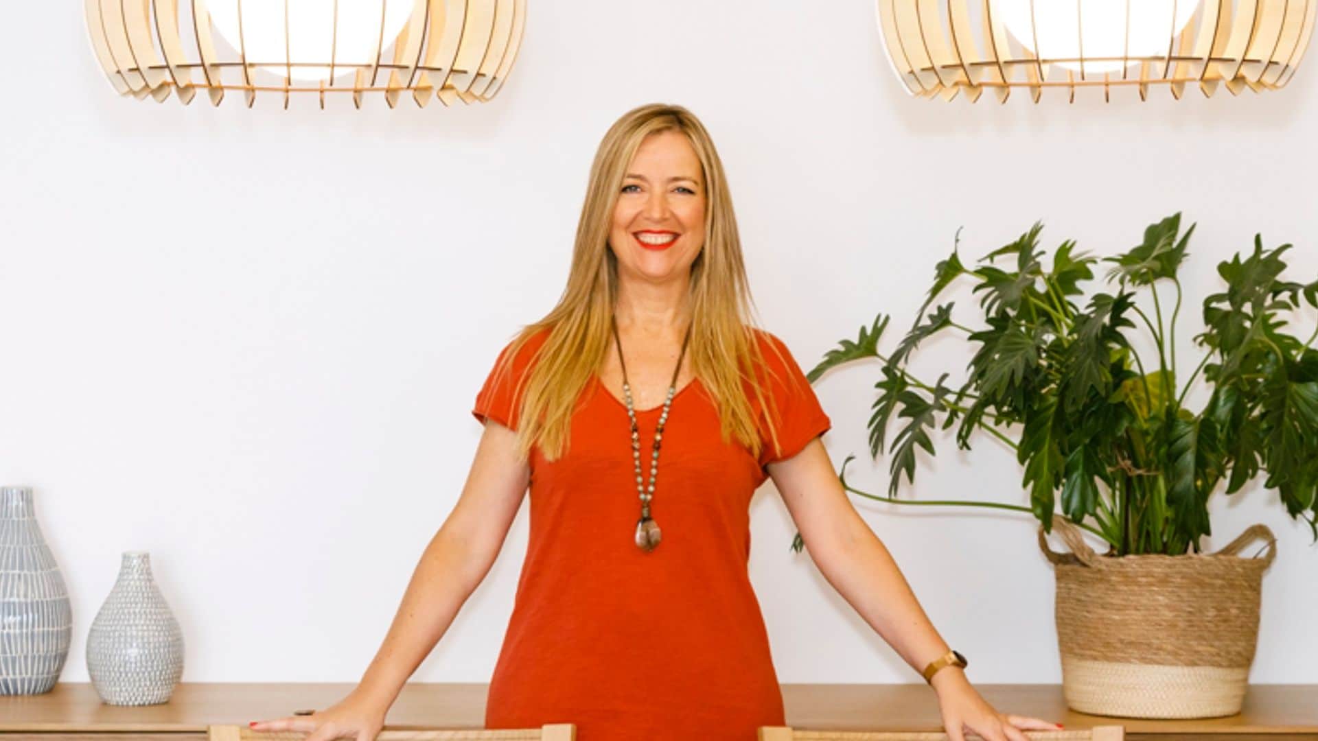 La experta en Feng Shui Montserrat Beltrán en comedor con mesa de madera, sillas de madera, lámparas de techo de fibras vegetales, estantería, aparador