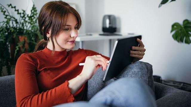 Una mujer con una tablet en un sofá