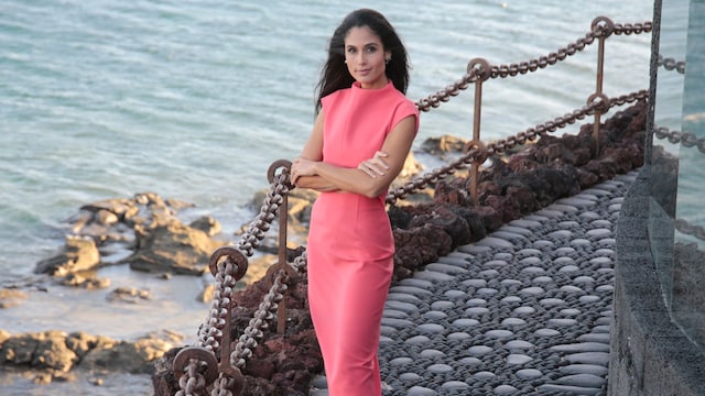 Plano entero de Patricia Yurena posando con vestido fuscia con el mar de fondo