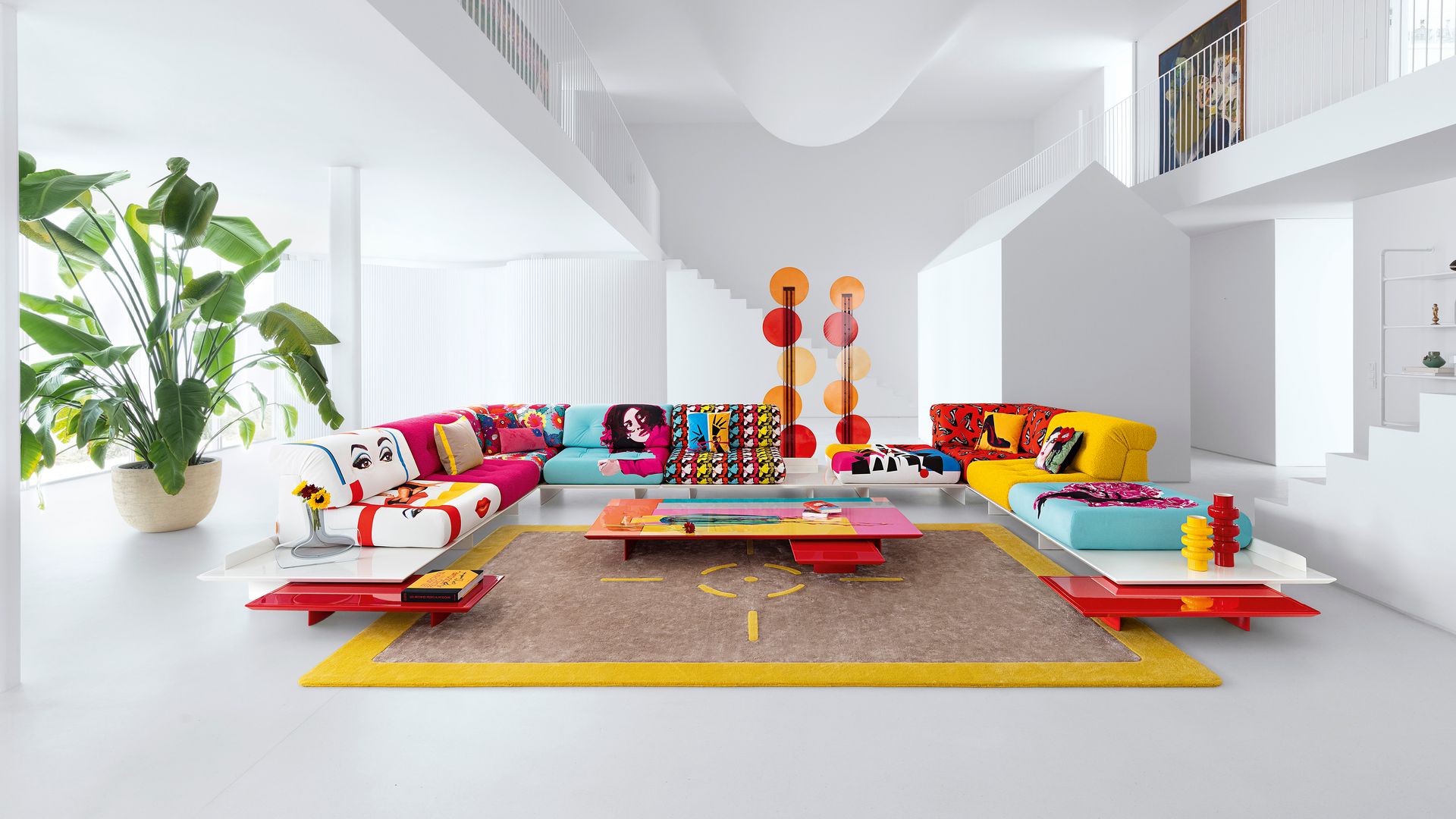 Salón con sofá modular en amarillo, rojo y azul, mesa de centro de colores, colección Pedro Almodóvar para Roche Bobois