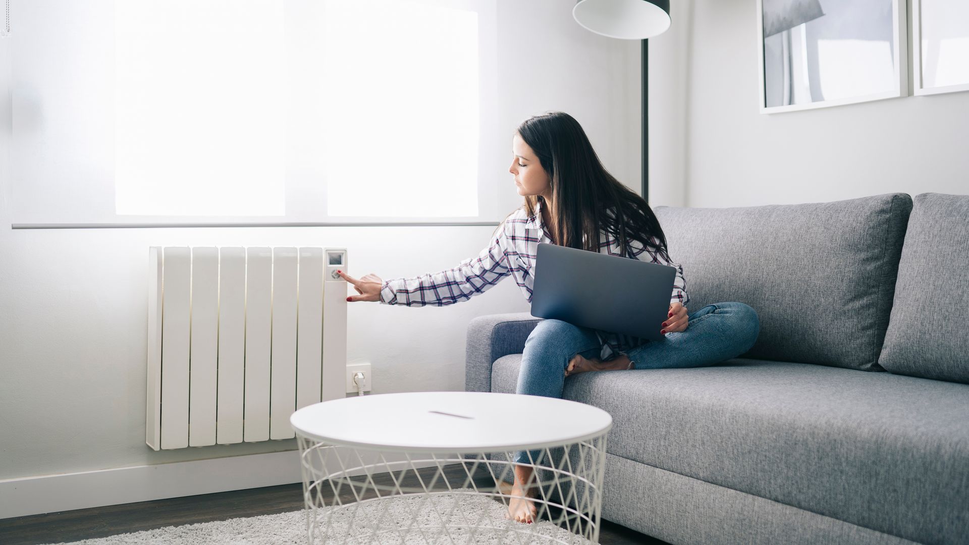 Mujer en casa comprobando un radiador de la calefacción de su casa