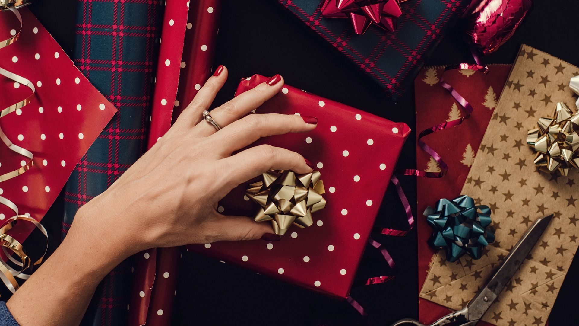Mano de mujer envolviendo regalos de Navidad