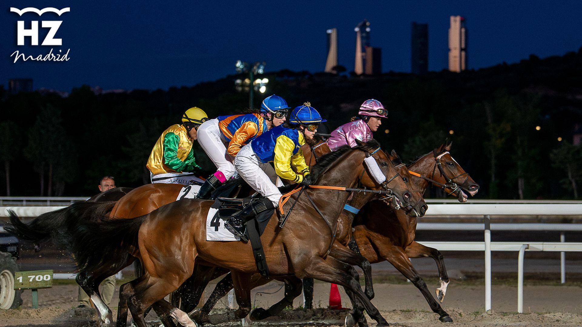 Pelotón con las cuatro torres de Madrid de fondo, carrera de caballos Hipódromo de la Zarzuela