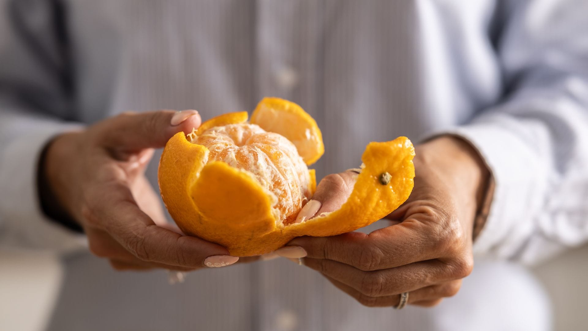 Una mujer pelando una naranja