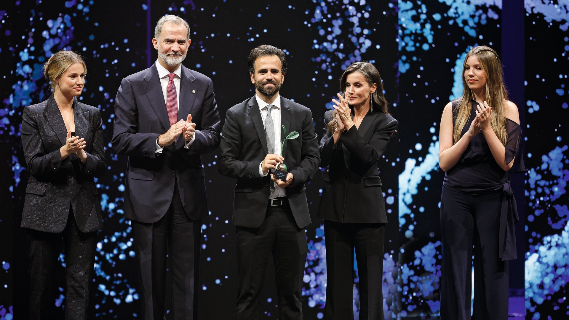 Los Reyes, la princesa Leonor y la infanta Sofía con el ingeniero Antoni Forner-Cuenca, que recibió el Premio Investigación 2025. La hija pequeña de los Reyes, con melena peinada con dos trencitas, llevó un mono en azul noche, de The Are, con capa asimétrica y lazada. Y, además, se puso por primera vez una joya, y no era una pieza cualquiera: el anillo de Karen Hallam, el preferido de la Reina, quien no se lo quitó ni un día desde el 24 de abril de 2019 al 22 de diciembre de 2022
