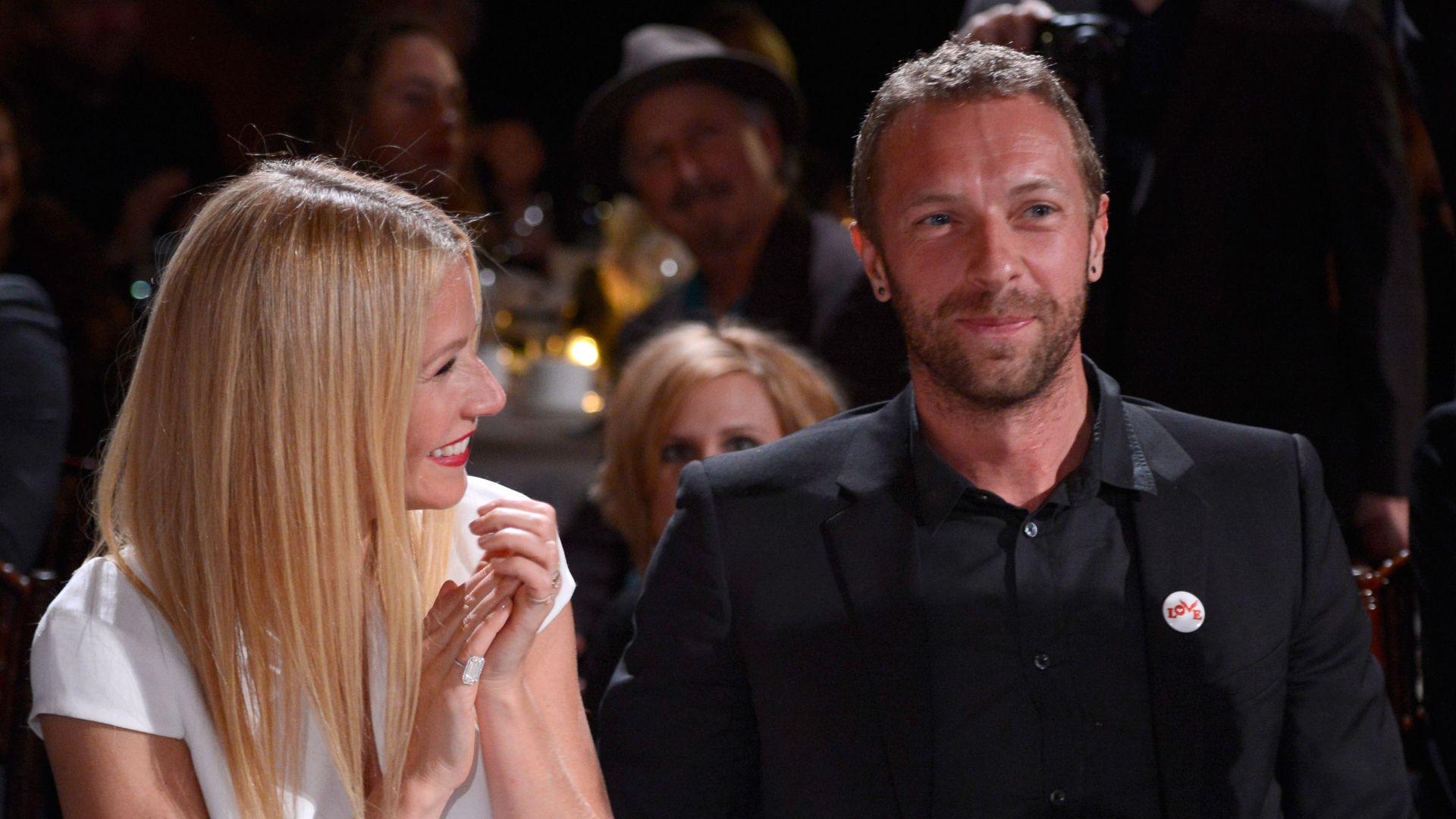 Plano medio de Gwyneth Paltrow y Chris Martin sentados en una gala de Giorgio Armani