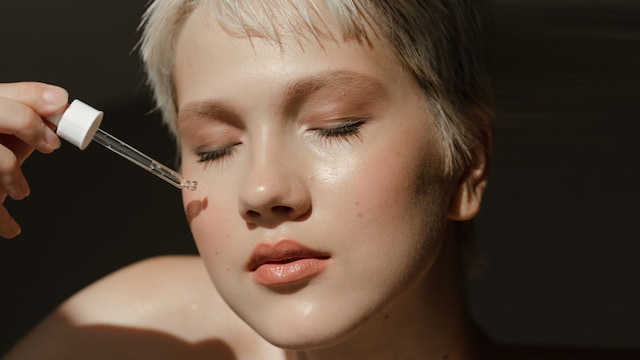 Rostro de mujer aplicándose sérum facial