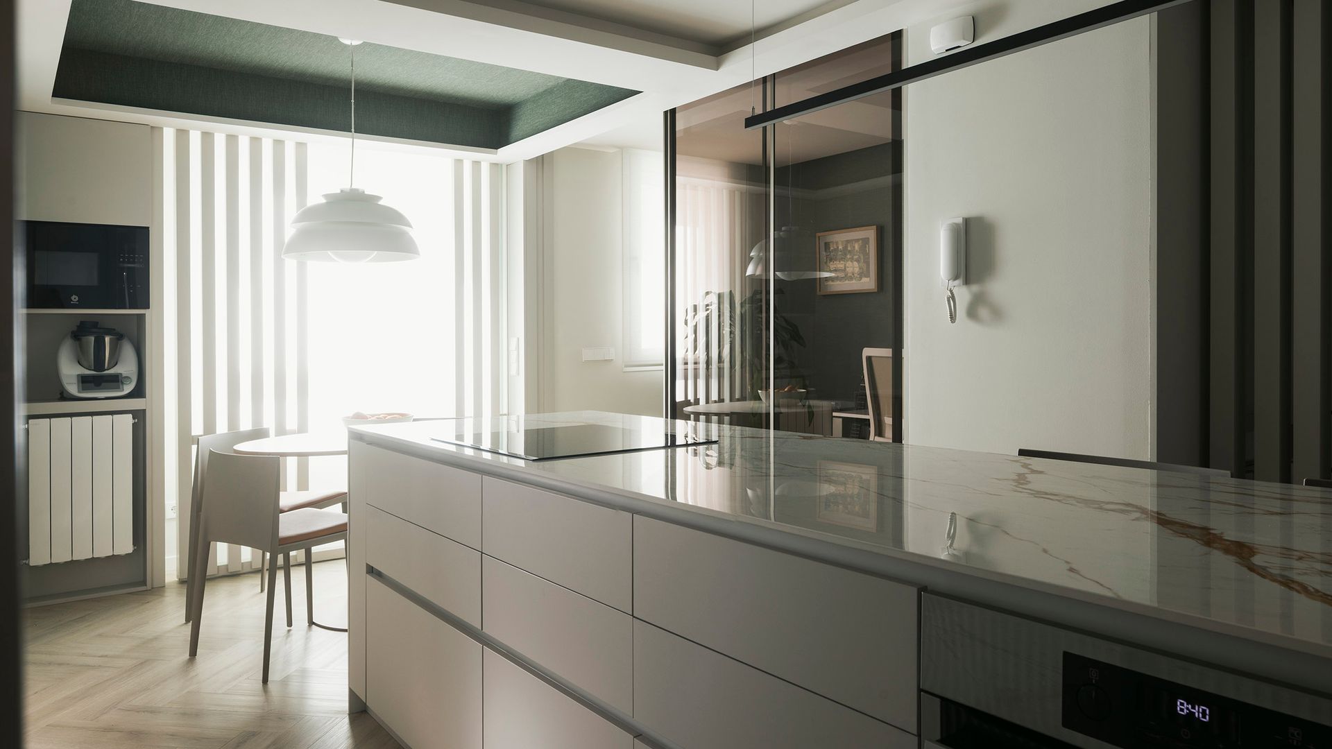 Cocina con isla central y comedor, radiador, campana en el techo 
