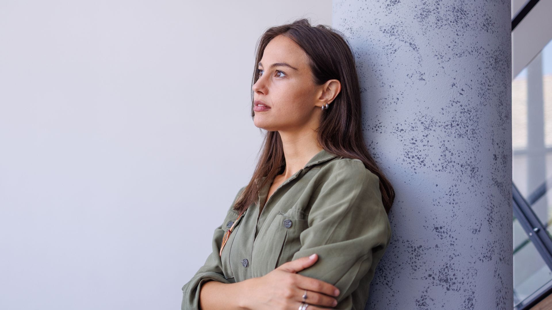 Una mujer de brazos cruzados mirando al horizonte
