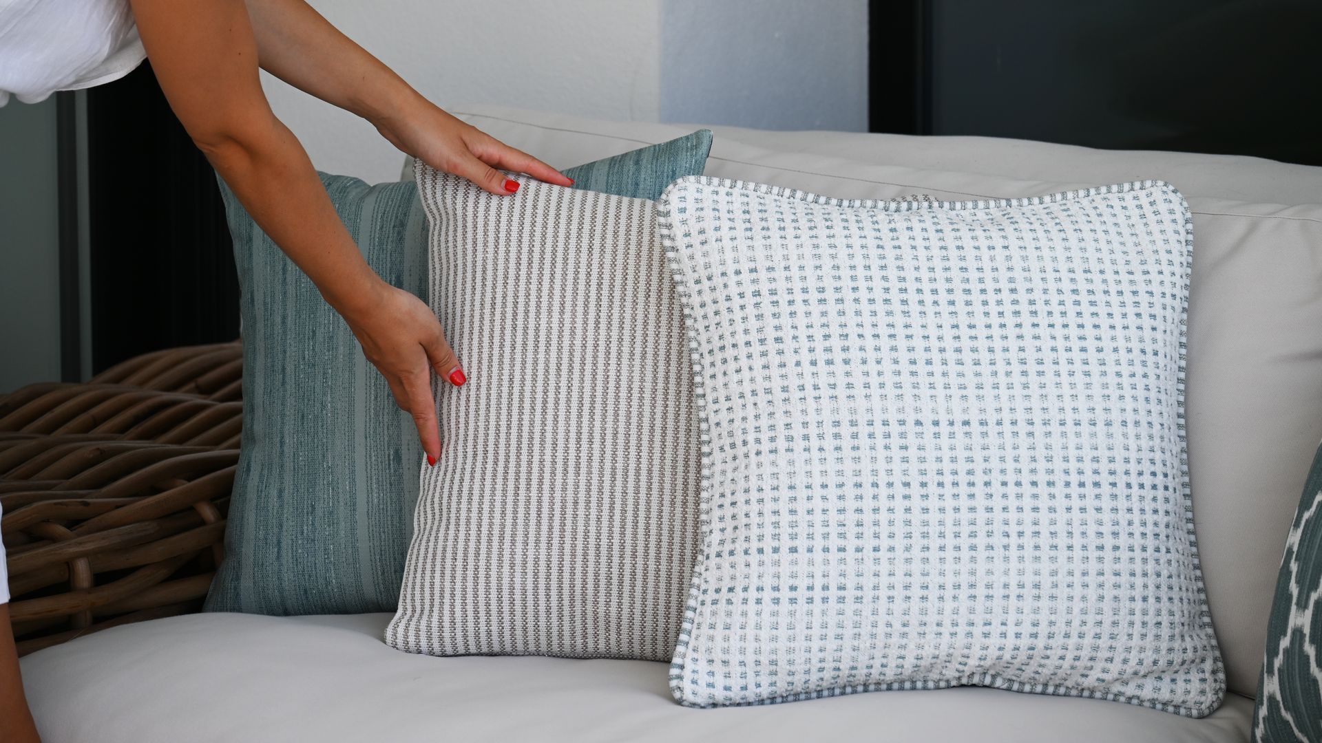 Mujer colocando cojines en el sofá