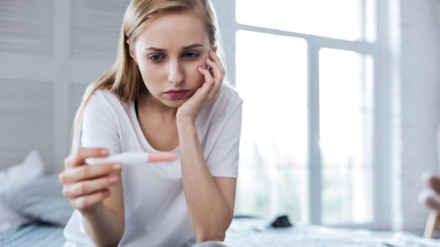 Mujer triste mirando un test de embarazo