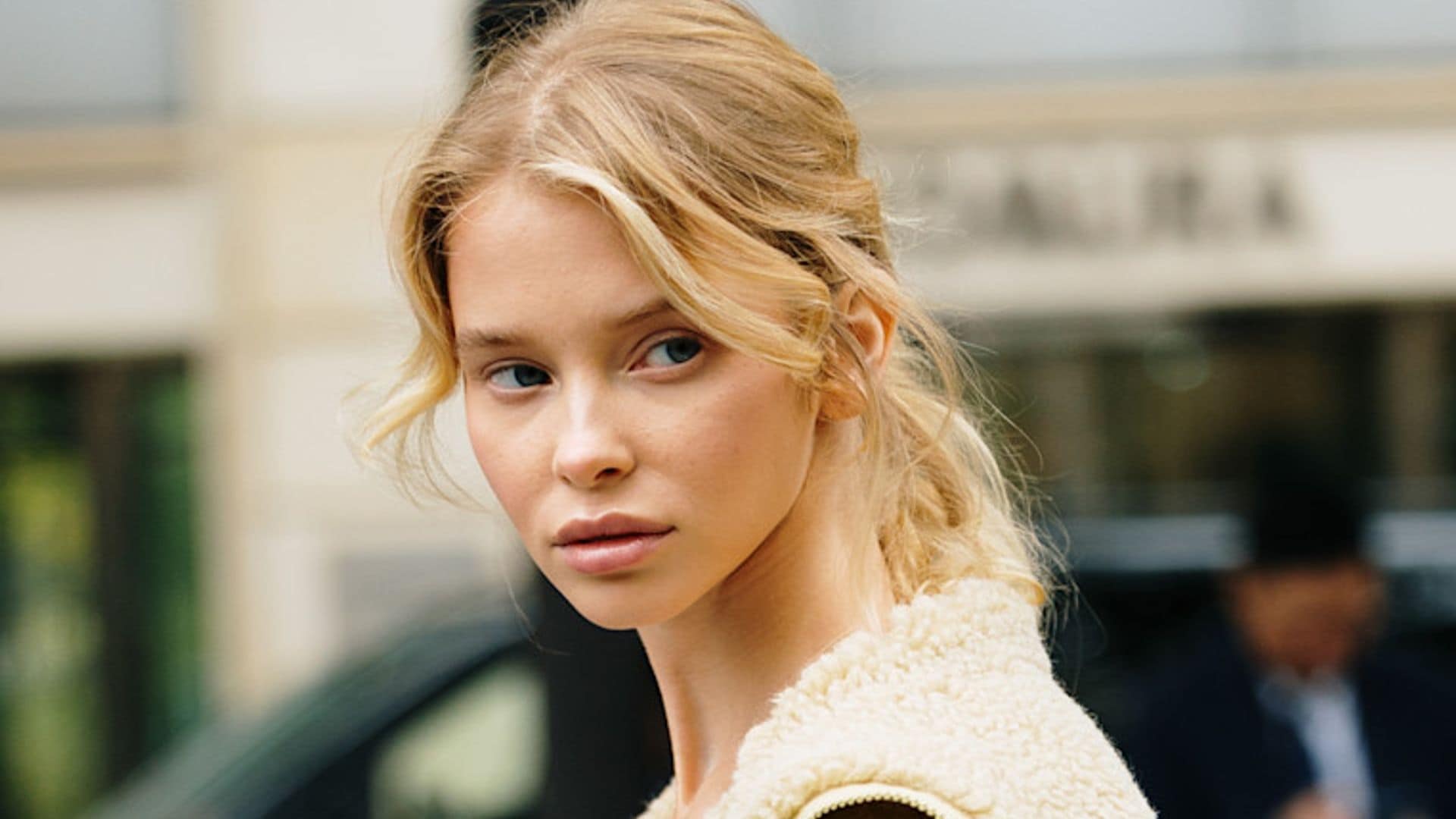 Chica rubia en el street style de París con cazadora beige de borrego