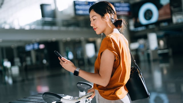 Una mujer en un aeropuerto con gadgets