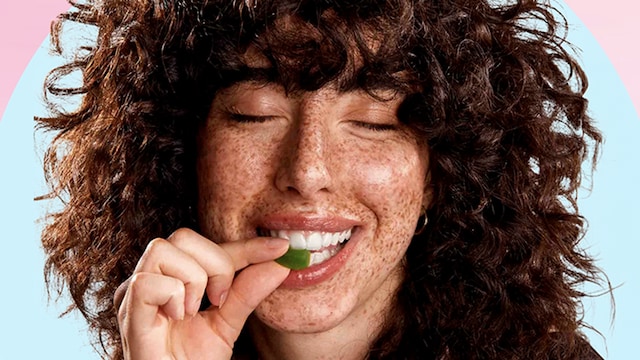 Chica mordiendo una gominola suplemento alimenticio para el cabello de Cocunat Cuadrada