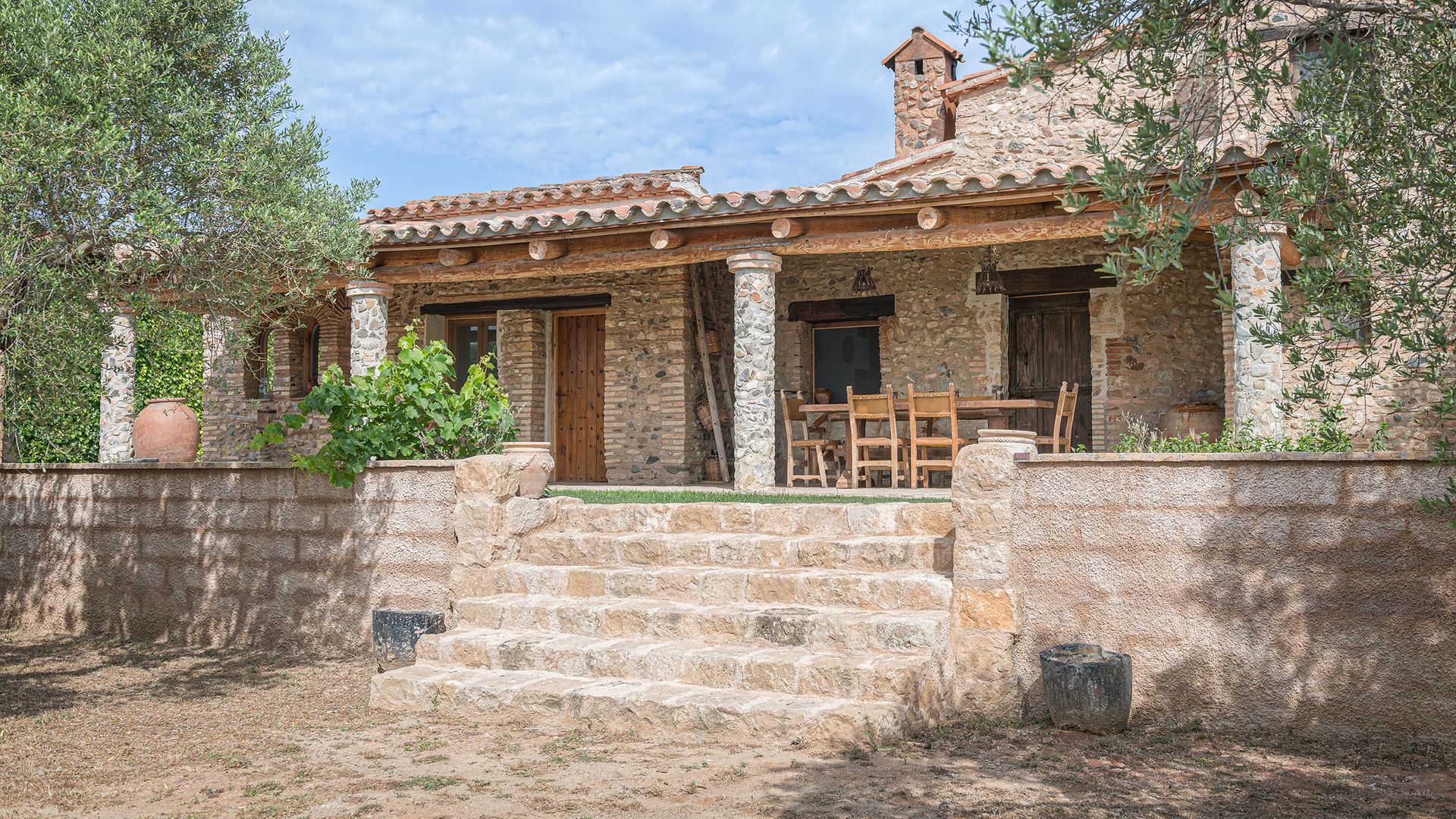 Masía catalana de piedra y porche con comedor exterior