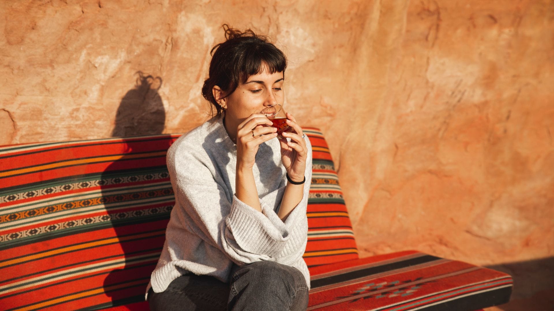 mujer tomándose un té sentada en un sofá