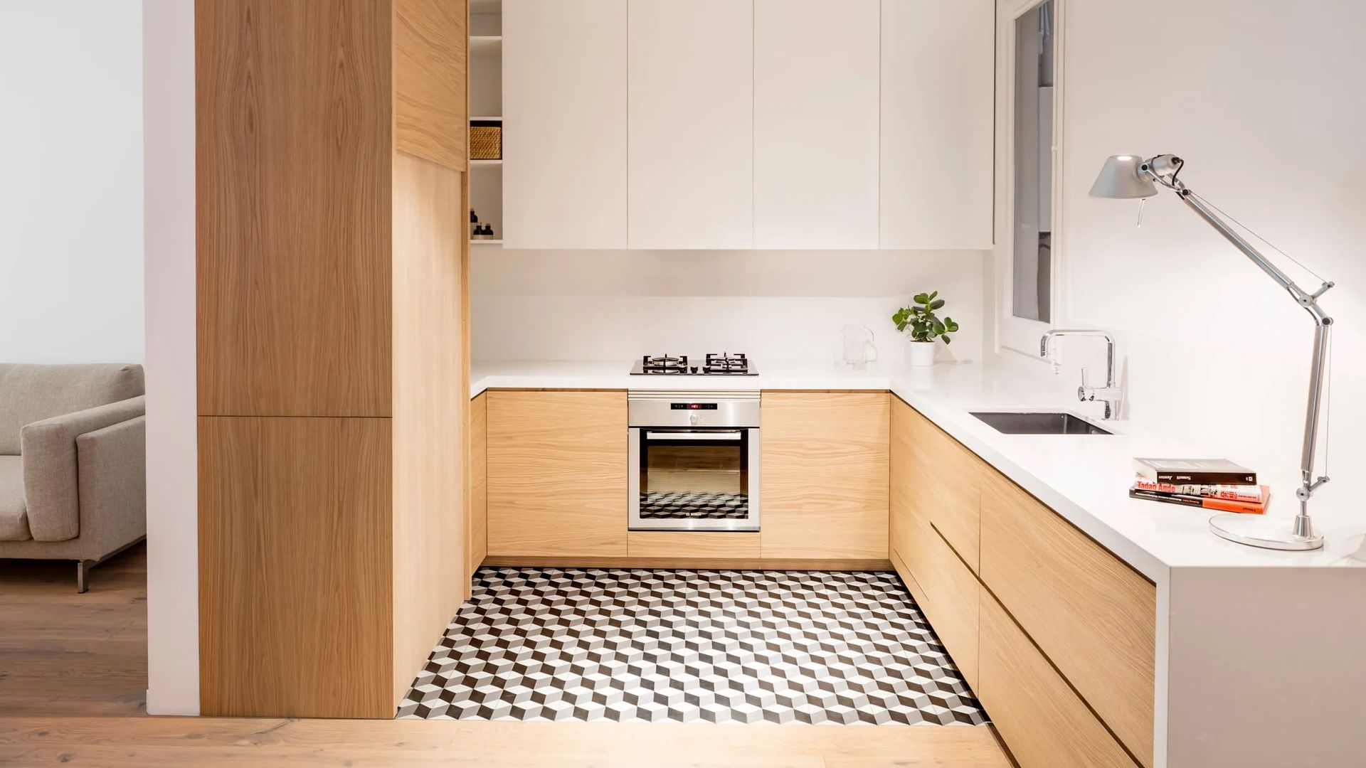 Cocina blanca y de madera con suelo hidráulico, flexo en la encimera, armario de madera