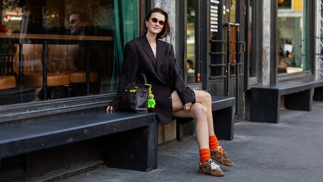 Marianne Theodorsen con blazer negra, bolso de mano y zapatillas new balance con calcetines naranjas