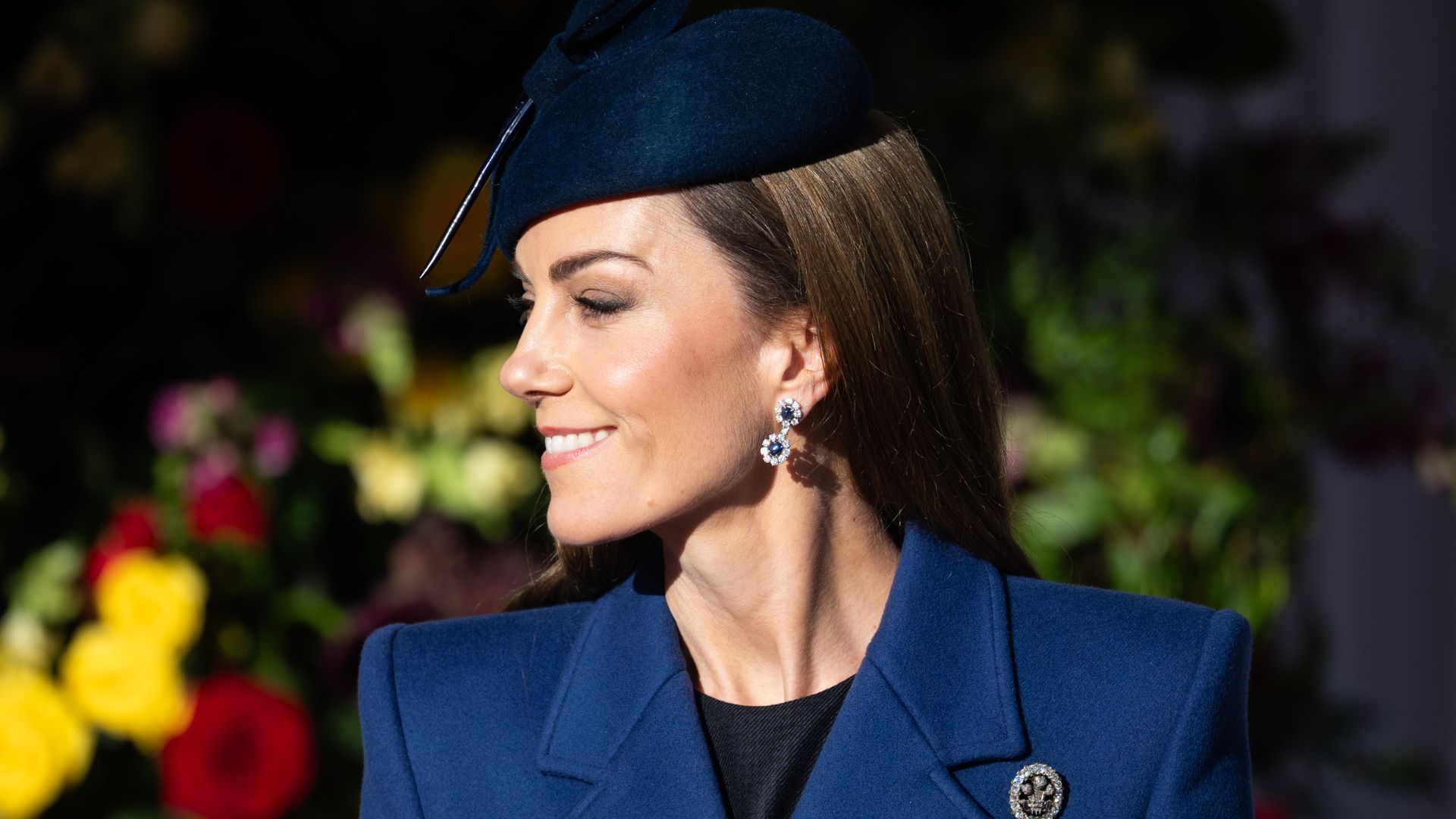 Kate Middleton con abrigo y tocado azules, pelo suelto liso y guantes en la bienvenida en el aeropuerto de Heathrow del presidente de la República Federal de Alemania
