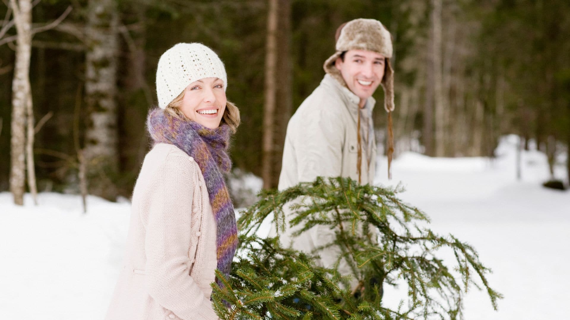 Una pareja en Navidad con un abeto para decorar